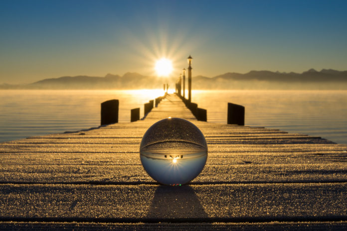 Ende der Welt Spiegelung eines Stegs in einer Glaskugel bei Sonnenuntergang