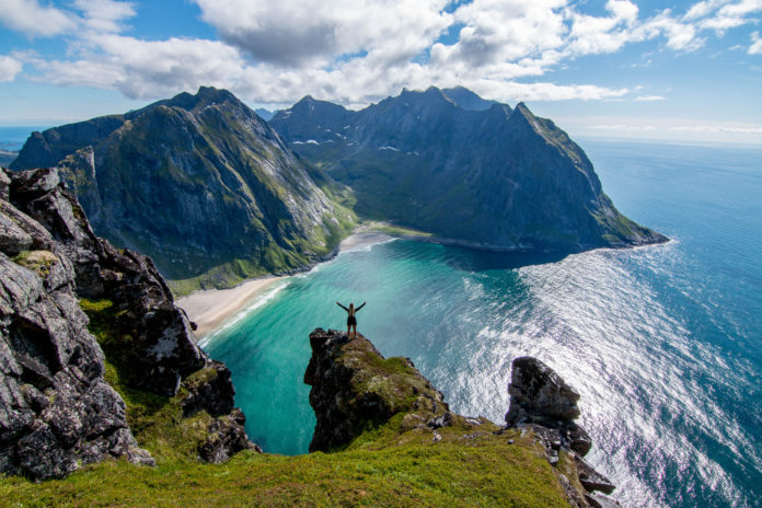 Wanderer der den Kvalvika Beach von oben bestaunt