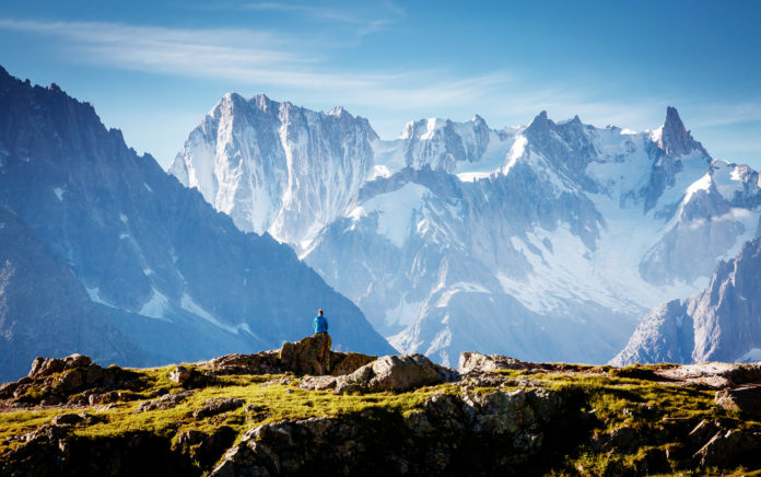 Mont Blanc Das Massiv des Mont Blanc mit Wanderer im Vordergrund