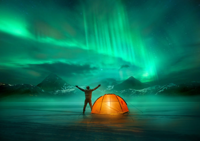 Camper mit seinem Zelt in Island unter Nordlichtern